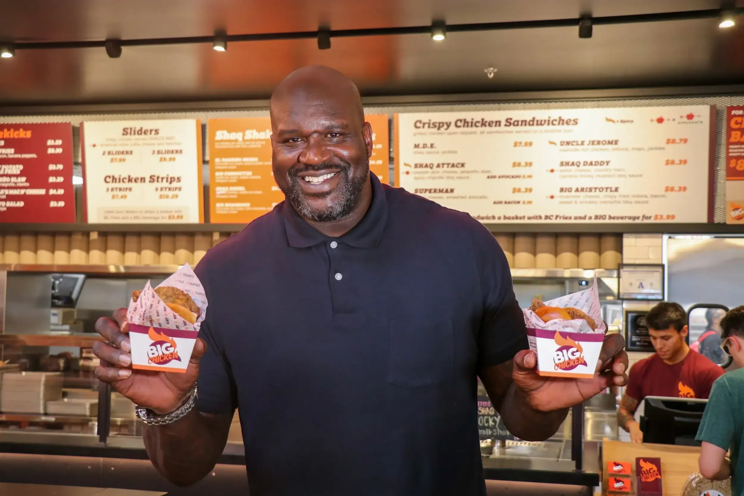shaq posing with big chicken sandwiches